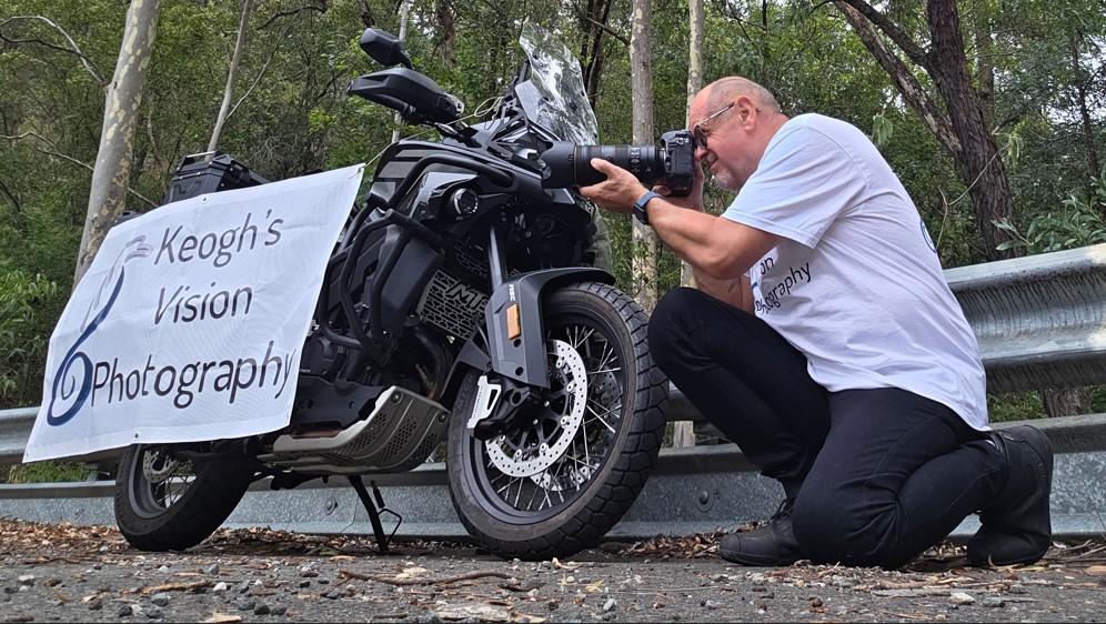 Keoghs Vision photographer shooting a black adventure motorcycle on a forest road
