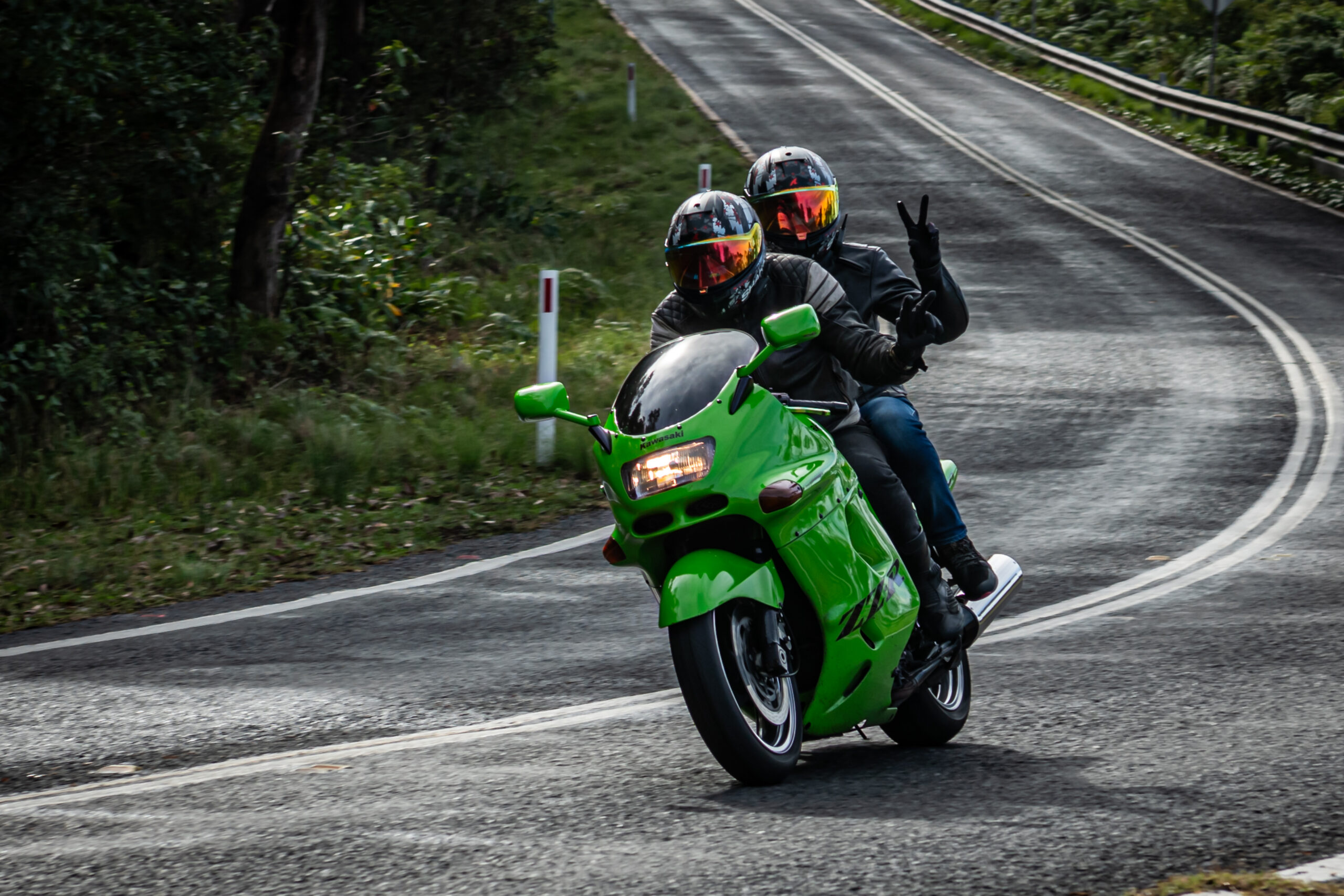 Motorcycle rider cornering through Royal National Park